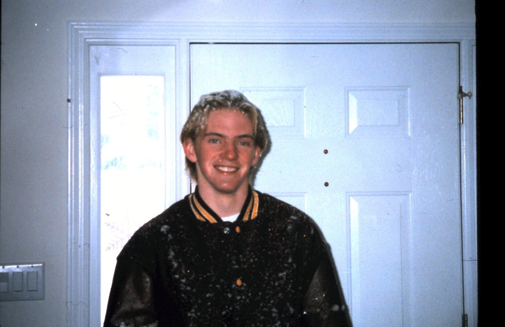 An image of photographer Adam Scott in High School wearing his letter jacket.
